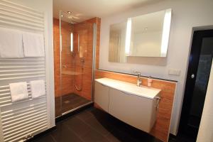 a bathroom with a sink and a shower with a mirror at Hotel Zum Goldenen Anker in Bamberg