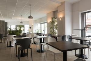 a restaurant with tables and chairs and windows at BRIT HOTEL CONFORT NEVERS Centre Gare in Nevers