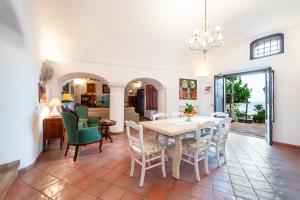 a dining room and living room with a table and chairs at Casa Claudius - Positano in Positano