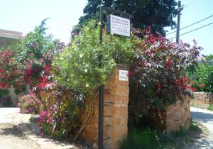 a sign on a brick wall with flowers at Kleidas Apartments in Thymianá