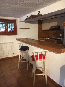 uma cozinha com duas cadeiras e uma bancada em Taverna tranquillissima indipendente em Trezzano sul Naviglio