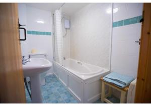 a bathroom with a sink and a tub and a toilet at Abbey Place Net Loft in Mousehole +14 photos