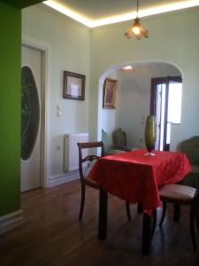 a dining room with a red table and chairs at Acropolis Apartment in Athens