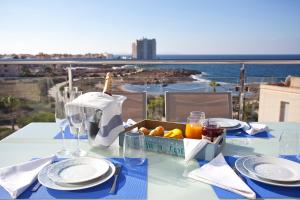 a table with a basket of fruit and a view of the ocean at Apartaments Posidonia in Colònia de Sant Jordi