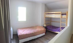 niewielka sypialnia z 2 łóżkami piętrowymi i oknem w obiekcie L'Oursiere w mieście Bédouès