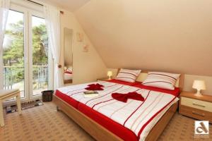 トラッセンハイデにあるStrandstrasse 21 Fewo 06のベッドルーム1室(赤い弓を使った大型ベッド1台付)