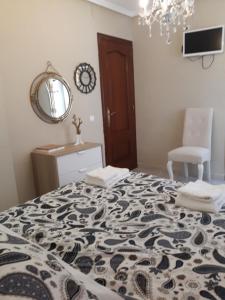 Un dormitorio con una cama, un espejo y una silla. en Cute Home Bethlem, en Cuenca