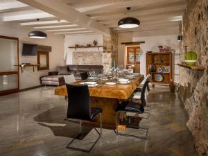 - un salon avec une grande table et des chaises en bois dans l'établissement Belvilla by OYO Villa Le Muse, à Scopello