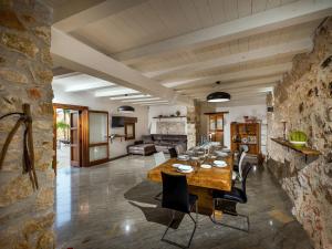 - un grand salon avec une table et des chaises en bois dans l'établissement Belvilla by OYO Villa Le Muse, à Scopello