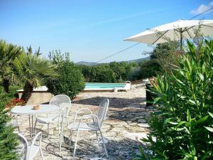 een tafel en stoelen met een parasol en een zwembad bij Belvilla by OYO Villa Ribattolino in Sasso Pisano
