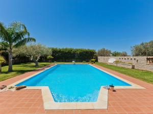 a large blue swimming pool in a yard at Belvilla by OYO Carta Dieci in Cinisi