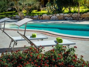 a pool with two lounge chairs and a swimming pool at Belvilla by OYO Beautiful Holiday Home near Beach in Castellammare del Golfo