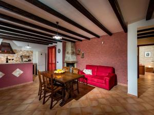 a living room with a red couch and a table at Belvilla by OYO Beautiful Holiday Home near Beach in Castellammare del Golfo