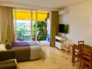 a bedroom with a bed and a balcony with a television at Magical Sea View Studios in Torremolinos