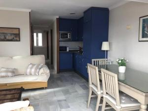 sala de estar con armarios azules, mesa y sofá en Apartamento Playa La Muralla, en El Puerto de Santa María