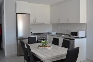 a kitchen with a table with chairs and a kitchen with a refrigerator at PRECIOSO APARTATAMENTO JUNTO AL MAR in Peñíscola