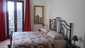 una camera con letto, specchio e finestra di Casa Galli a Castel Giorgio