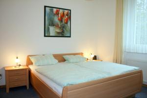 1 dormitorio con 1 cama y una pintura en la pared en Hotel Haus Hellhohl Garni, en Brilon