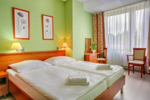 ein Schlafzimmer mit einem großen weißen Bett in einem Zimmer in der Unterkunft Ensana Spa Smrdáky in Smrdáky + 28 Fotos