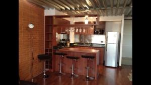 a kitchen with a bar with stools and a refrigerator at Barceló Suites Providencia I in Santiago