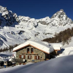 una cabaña en la nieve con una montaña cubierta de nieve en Baita Layet, en Breuil-Cervinia