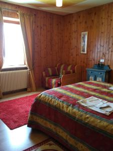 a bedroom with a bed and a couch at Baita Layet in Breuil-Cervinia