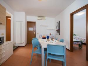 a dining room with a table and blue chairs at Bungalow in Po Delta Park with Beach Access in Lido di Spina