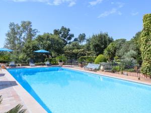uma grande piscina com cadeiras e árvores em Characteristic mansion in Fr jus with pool em Fréjus
