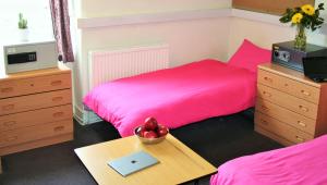 een slaapkamer met 2 bedden en een tafel met een laptop bij Railton House (Paddington) in Londen