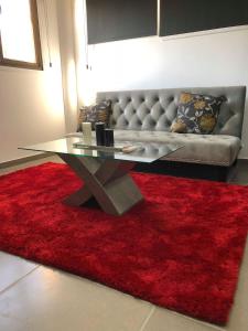 sala de estar con mesa de cristal y alfombra roja en Central Luxury Studios, en Ayia Napa