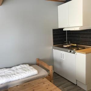 eine kleine Küche mit einem Bett und einem Waschbecken in der Unterkunft Lofoten Feriesenter in Svolvær