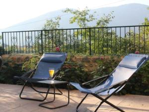 une paire de chaises et un verre de vin sur le balcon dans l'établissement Belvilla by OYO Villa Fiorita Tre, à Romano D'Ezzelino