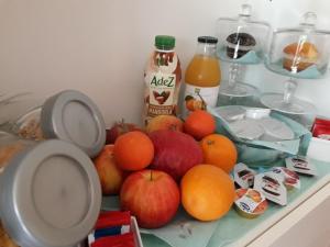 una mesa con manzanas naranjas y botellas de zumo en A Casa di Grace en Basiglio