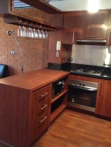 a kitchen with wooden cabinets and a stove top oven at Barceló Suites Providencia I in Santiago