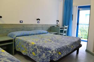 een slaapkamer met 2 bedden, een tafel en een raam bij Hotel Playa e Mare Nostrum in Caorle