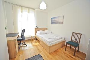 a bedroom with a bed and a desk and a chair at Grand Apartments - Three bedrooms with panorama of the Old Town in Gdańsk