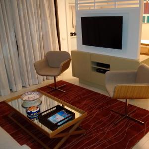 a living room with two chairs and a flat screen tv at Ocean Flat in Rio de Janeiro