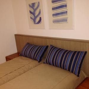a couch with two pillows on top of it at Ocean Flat in Rio de Janeiro