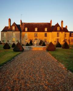 una casa grande con una entrada de grava delante de ella en Château d'Hodebert en Saint-Paterne-Racan