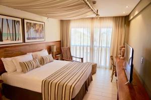 um quarto de hotel com uma cama e uma janela em Samoa Beach Resort em Porto de Galinhas