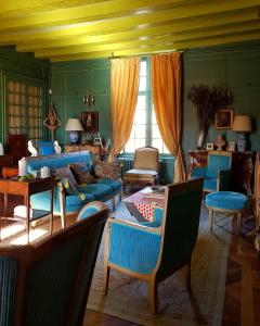 a living room with blue furniture and a yellow ceiling at Château d'Hodebert in Saint-Paterne-Racan