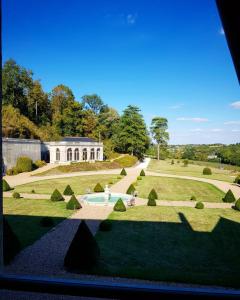 uma vista para um jardim com um edifício ao fundo em Château d'Hodebert em Saint-Paterne-Racan