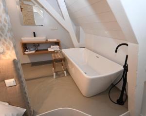 a bathroom with a sink and a bath tub at Hotel 't Fnidsen in Alkmaar