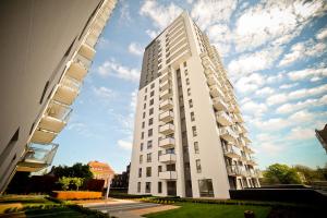 グダニスクにあるGrand Apartments - Three bedrooms with panorama of the Old Townの高い白い道のアパートメントビル