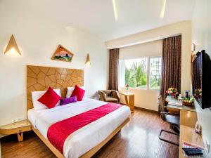 a hotel room with a large bed and a window at Hotel Rockdale in Visakhapatnam