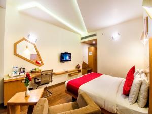 a hotel room with a bed and a desk at Hotel Rockdale in Visakhapatnam