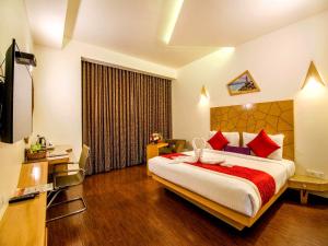 a hotel room with a large bed with red pillows at Hotel Rockdale in Visakhapatnam +37 photos