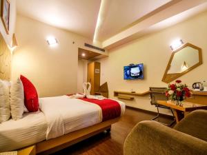 a hotel room with a bed and a tv at Hotel Rockdale in Visakhapatnam