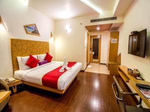a hotel room with a bed and a television at Hotel Rockdale in Visakhapatnam