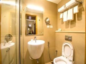 a bathroom with a toilet and a sink and a shower at Hotel Rockdale in Visakhapatnam